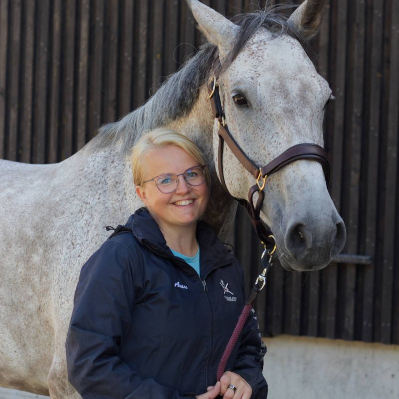Anu Hanhela hevosen vieressä.