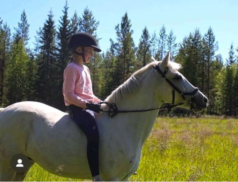 Tyttö taluttaa hevosta.