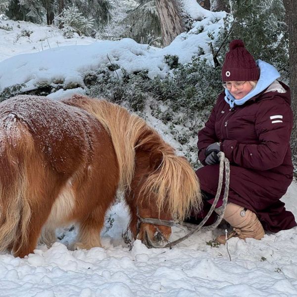 Anu Hanhela hevosen vieressä.